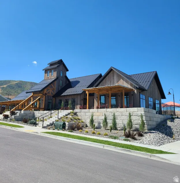 View of front of clubhouse featuring a standing seam roof, board and batten siding, a porch, and a mountain view