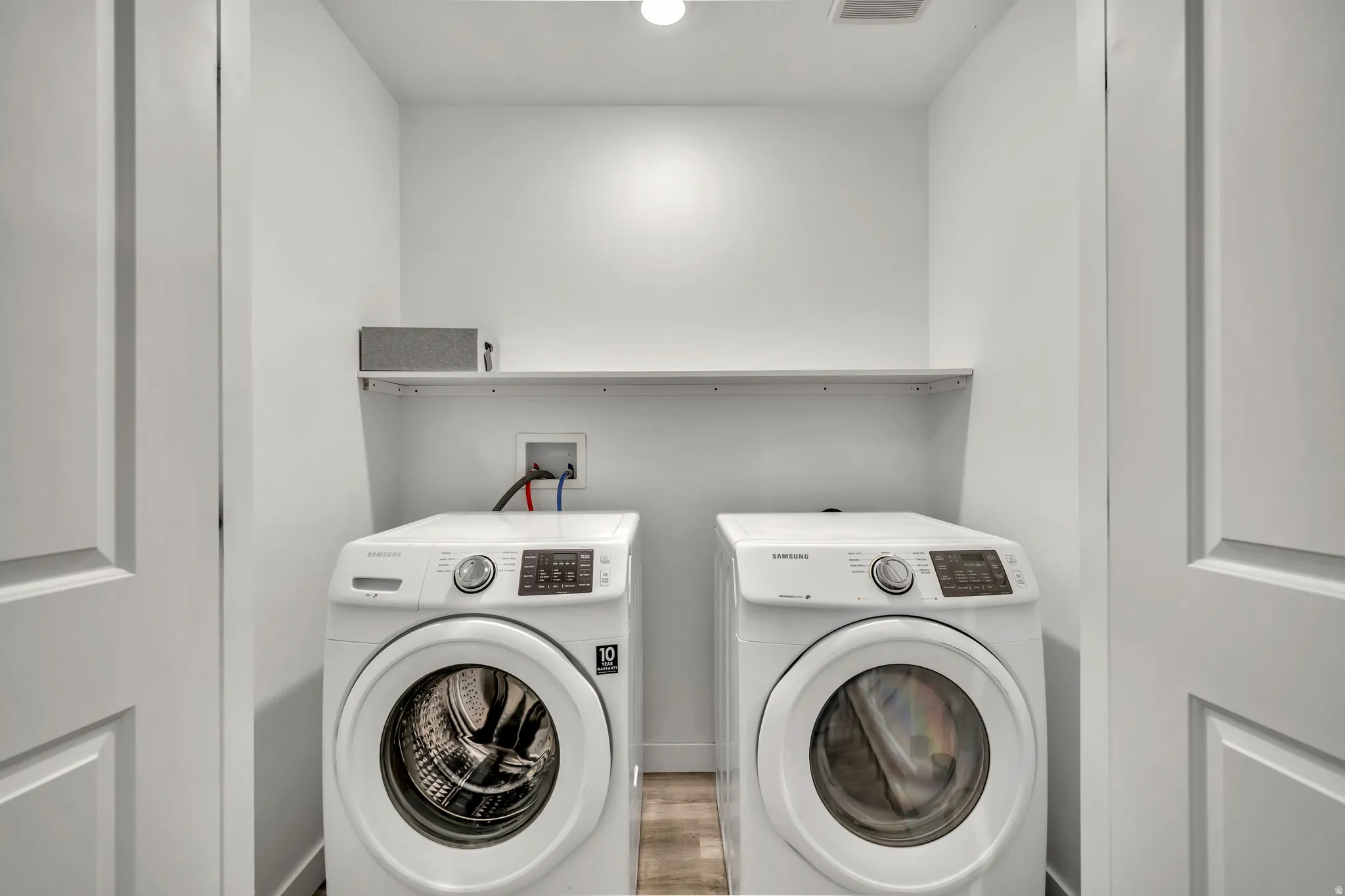Upstairs laundry area featuring washing machine and clothes dryer and LVP finished floors