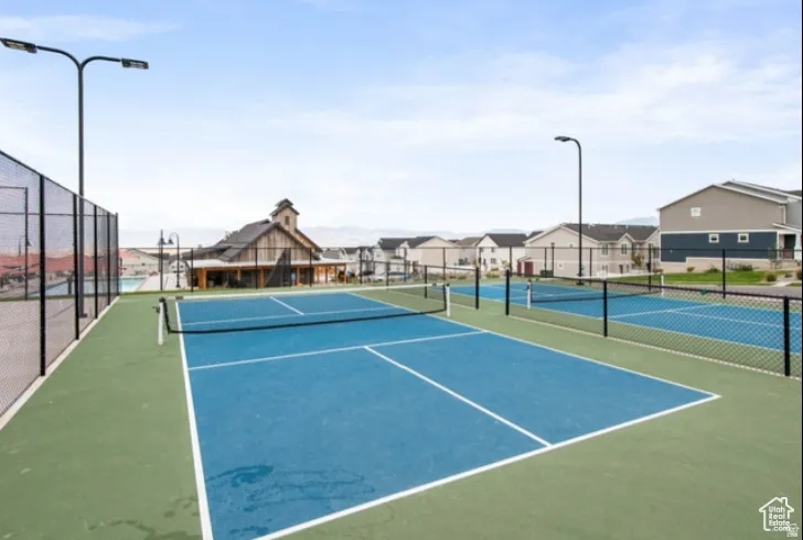 View of tennis court featuring a residential view