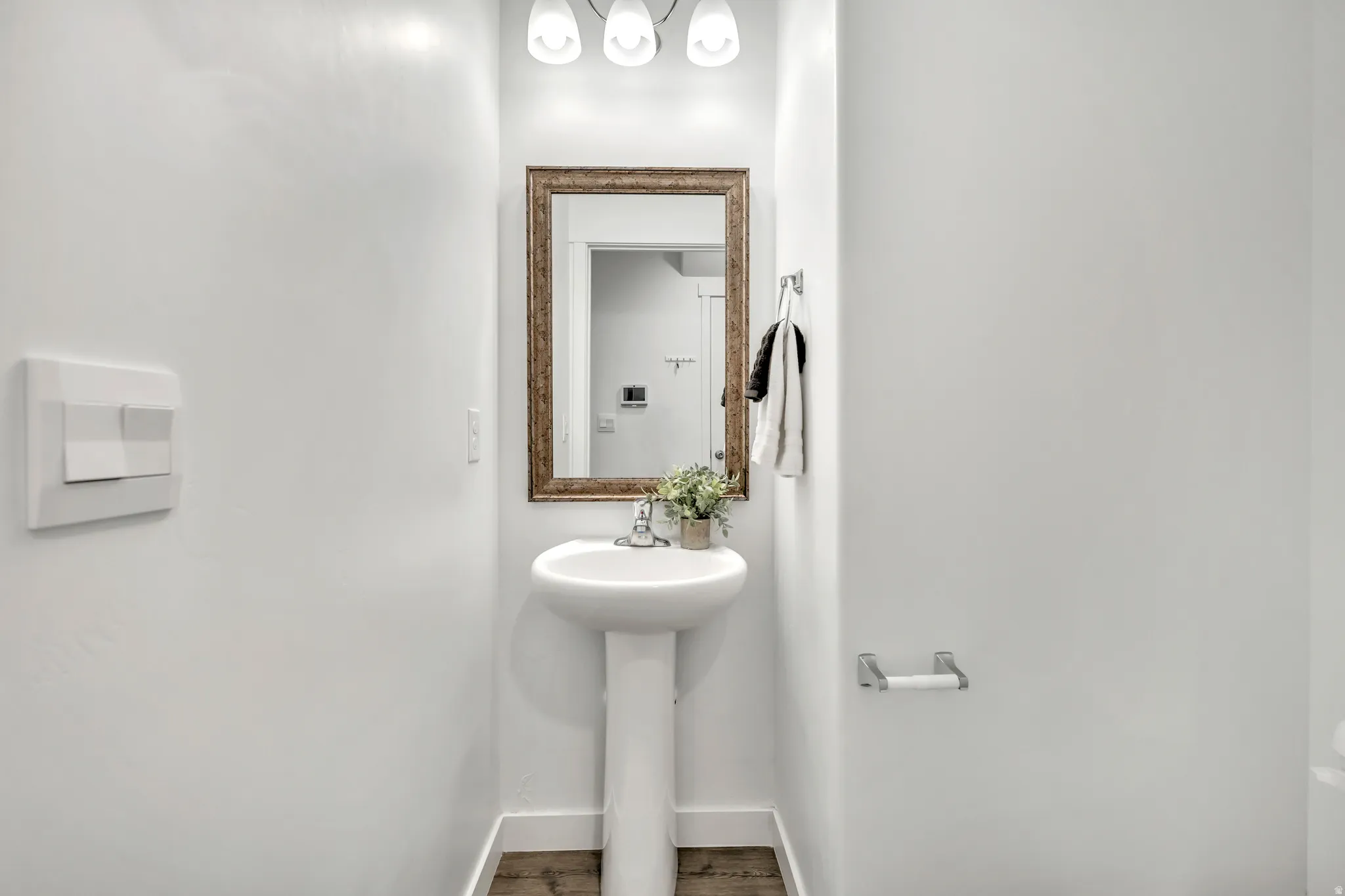 Powder room with baseboards and wood finished floors