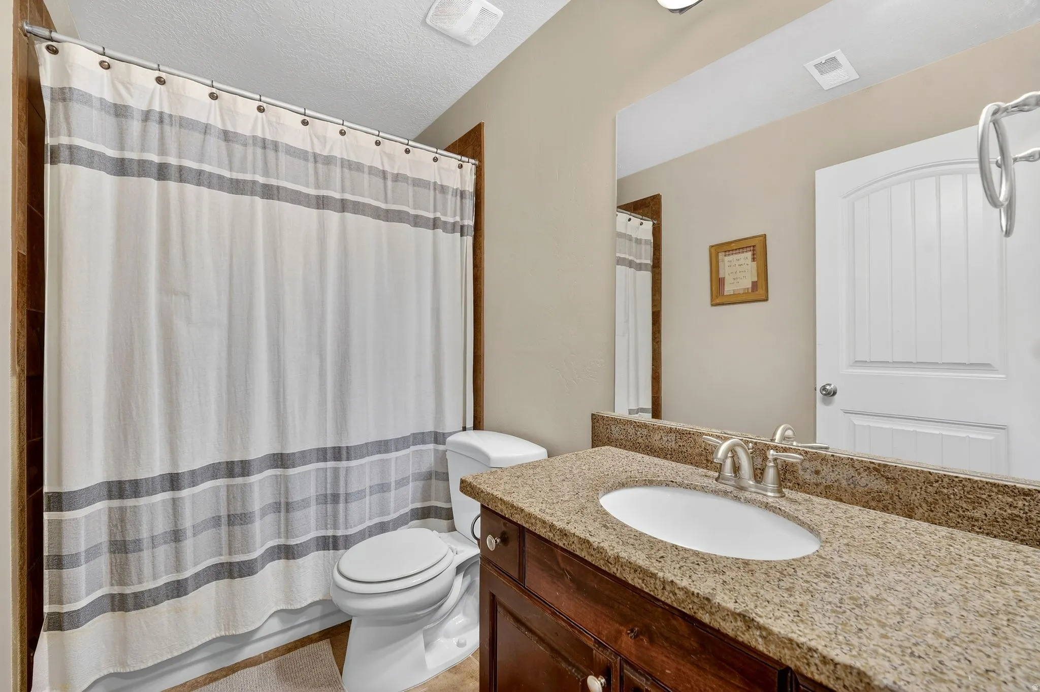 Full bathroom with vanity and a textured ceiling