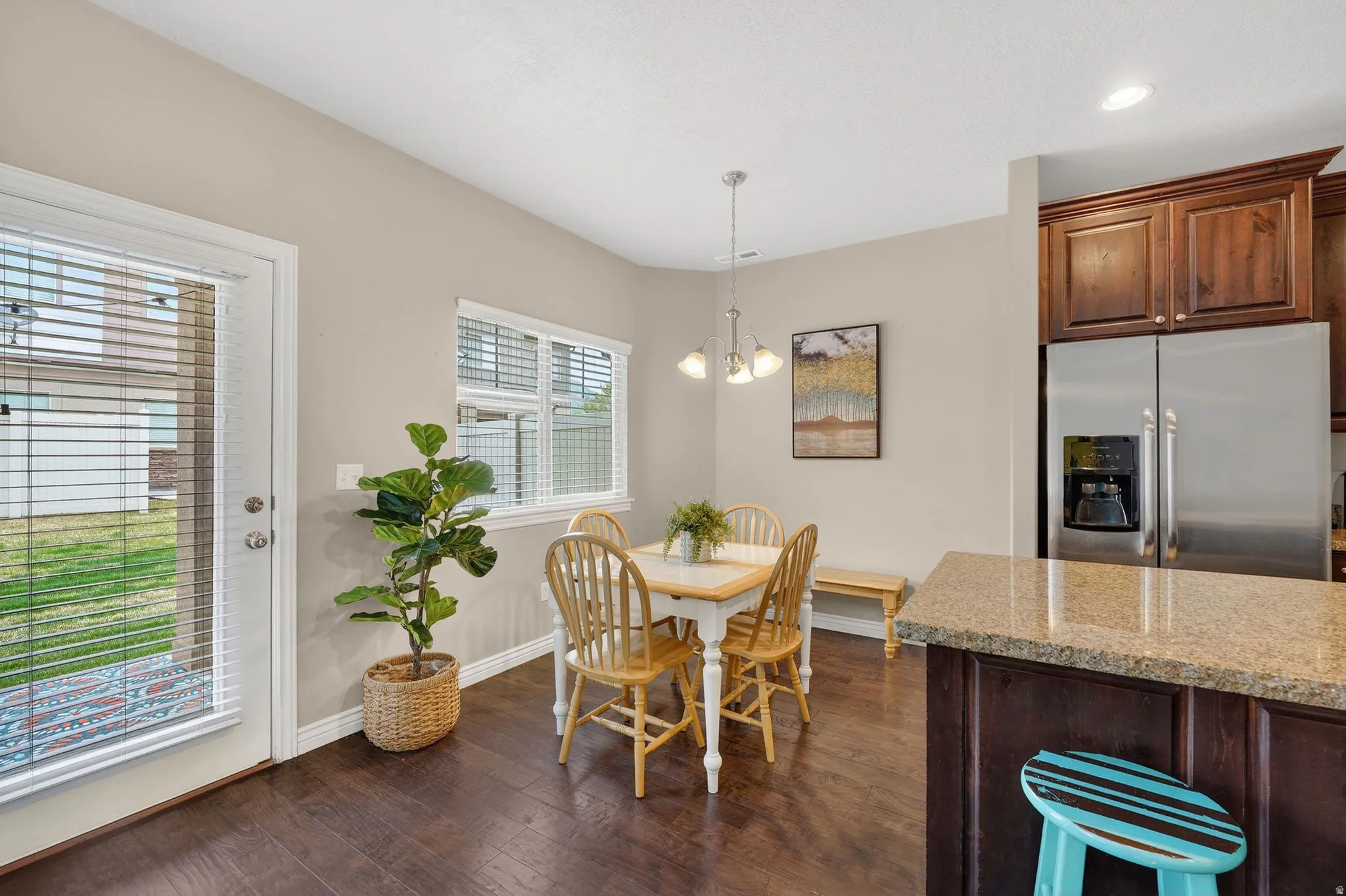 Dining area with dark wood finished floors and a chandelier