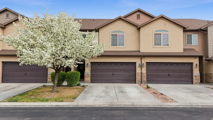 View of front of home featuring stucco siding, stone siding, concrete driveway, and a garage