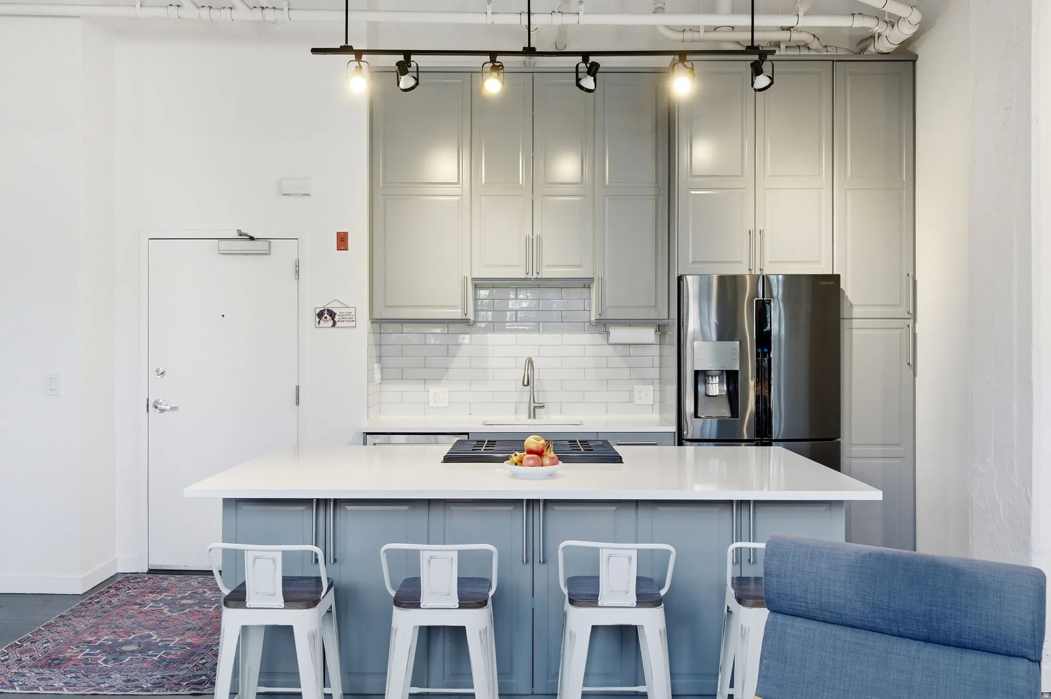Kitchen featuring gray cabinetry, a kitchen bar, a center island, tasteful backsplash, and stainless steel gas cooktop