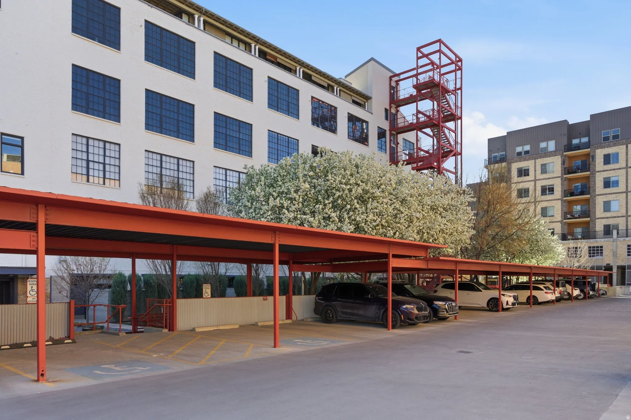 View of apartment building / complex featuring covered parking