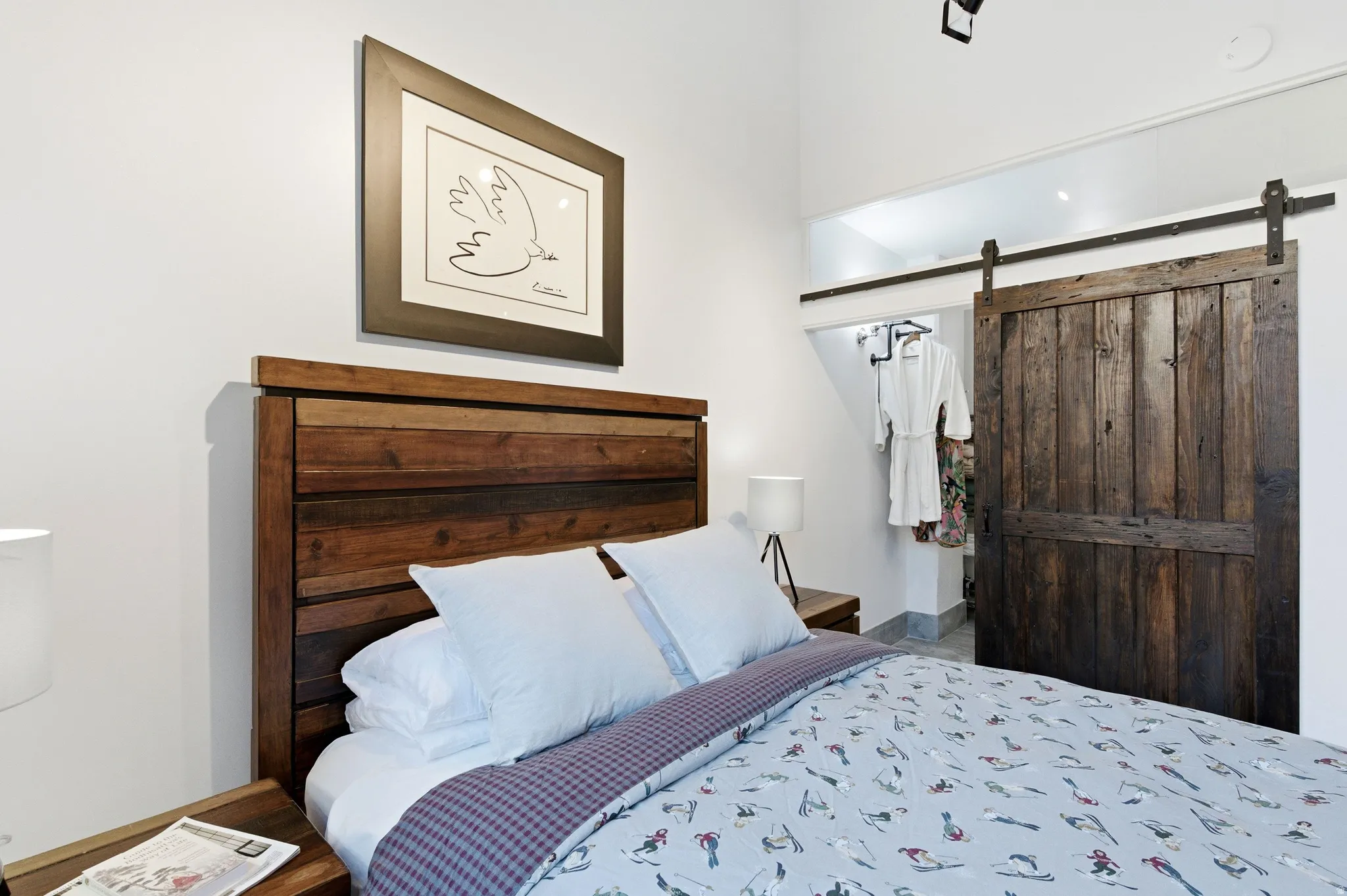 Bedroom with a barn door and wood finished floors
