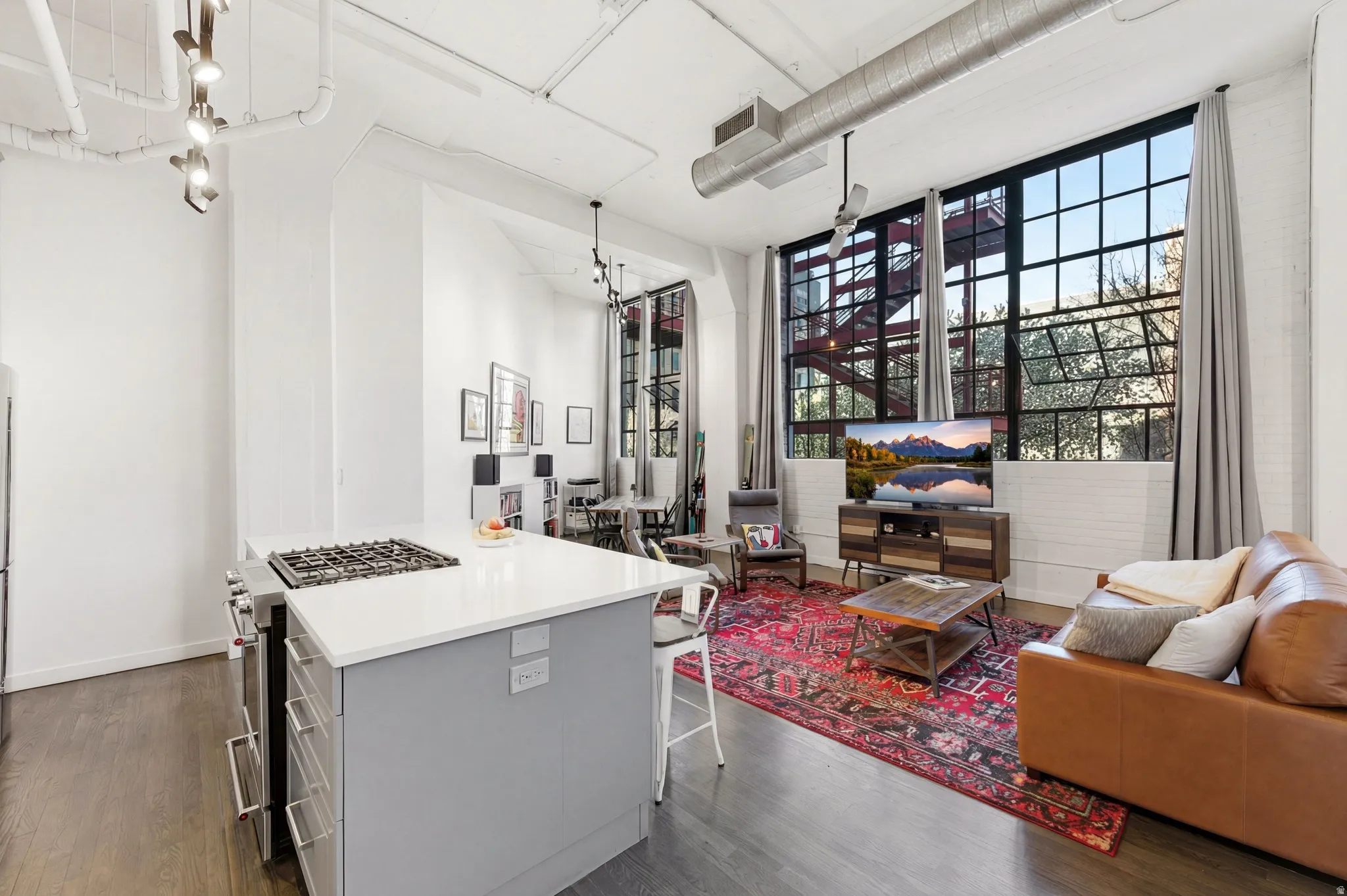 Kitchen with a kitchen bar, gas stove, open floor plan, a kitchen island, and a high ceiling