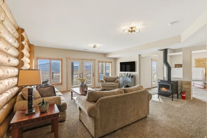 Living room featuring a wood stove, carpet, and log walls