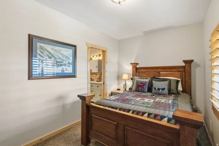 Bedroom featuring connected bathroom and carpet