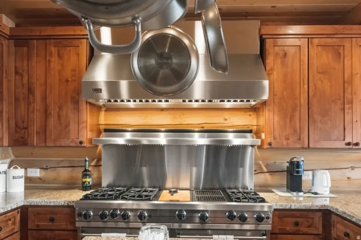 Kitchen featuring light stone counters, range with two ovens, wooden ceiling, and wood finish cabinets