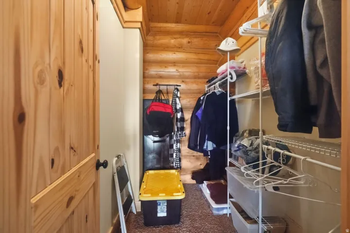 Walk in closet featuring dark colored carpet