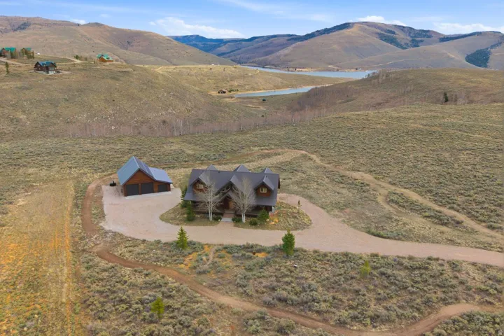 Aerial view of property and surrounding area featuring a water and mountain view
