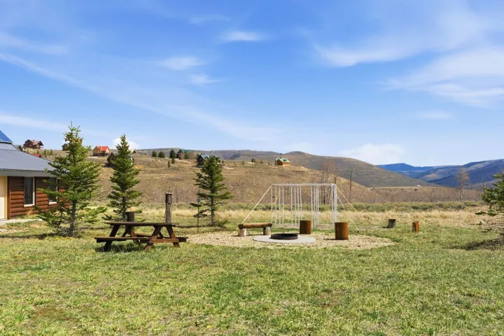 View of green lawn featuring a fire pit and a mountain view