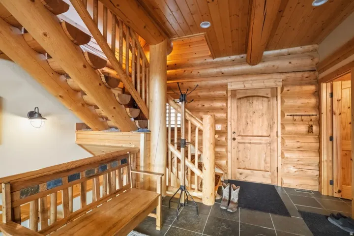 Stairs featuring log walls, a wood ceiling with exposed beams, and tile patterned floors