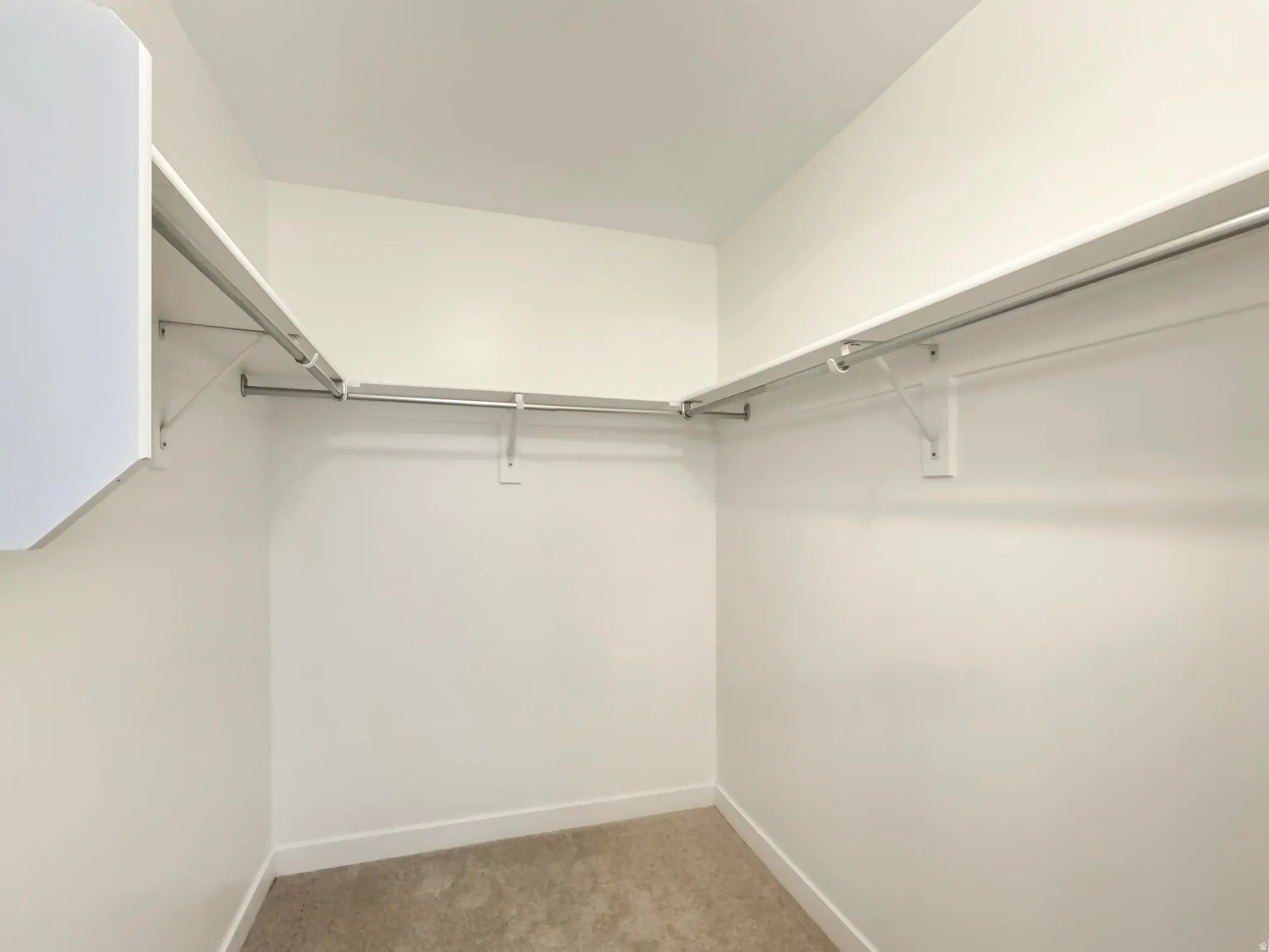 Master Bed, walk-in closet with light colored carpet