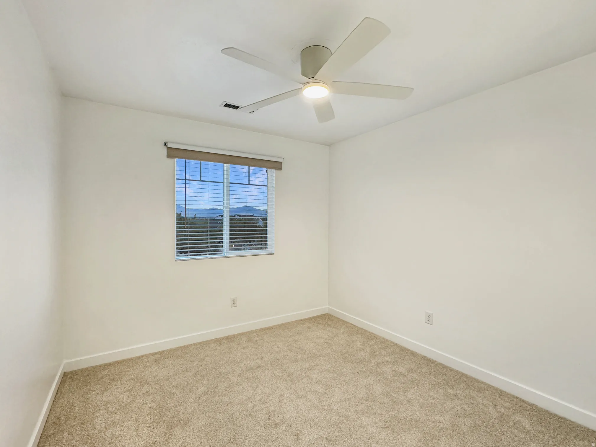 Upstairs bedroom with a ceiling fan.