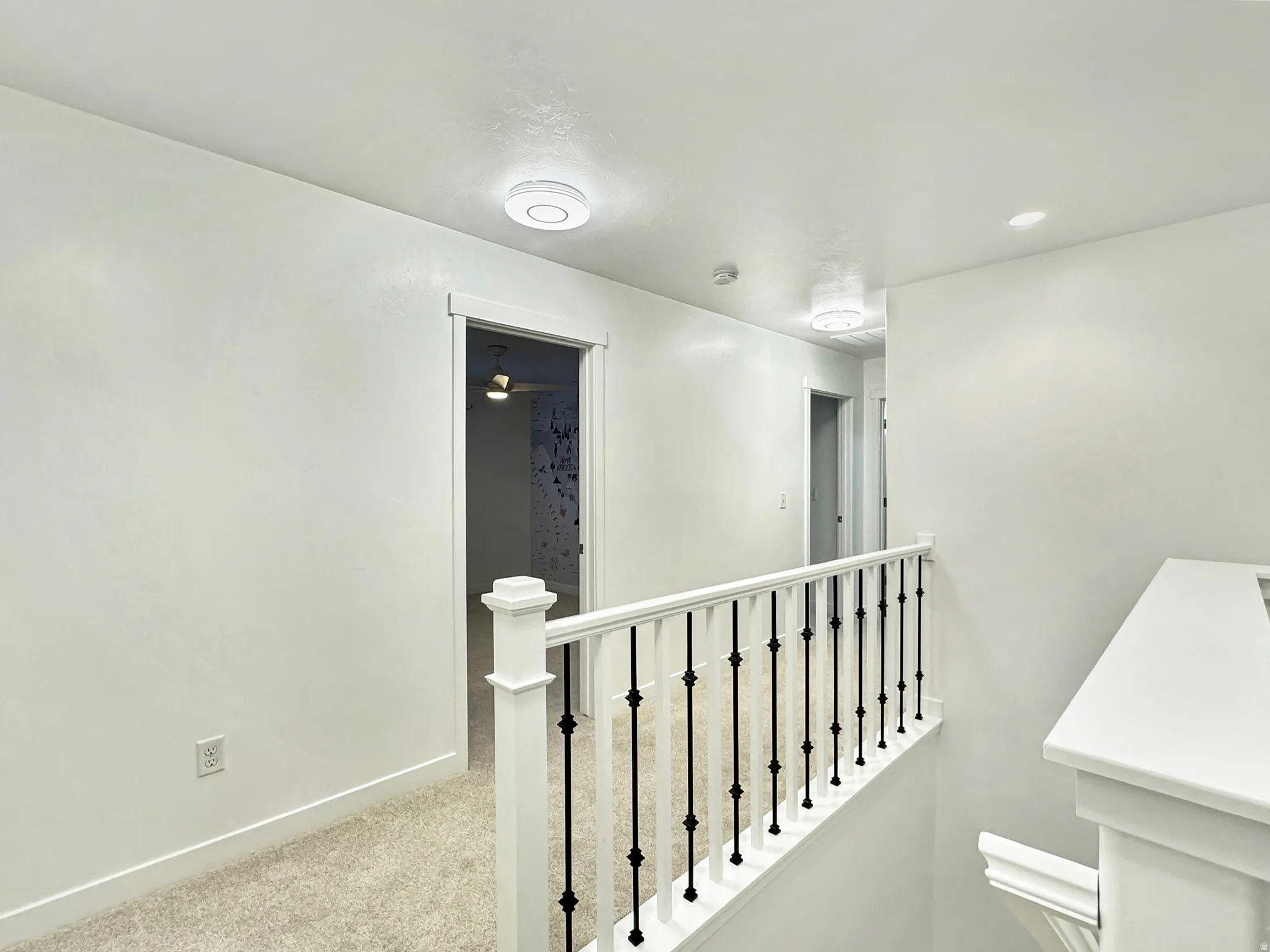 Hall with an upstairs landing, carpet floors, and recessed lighting