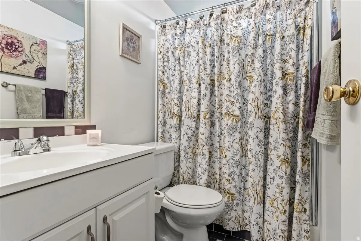 Full bath featuring vanity, a shower with glass sliding doors and tile patterned floors