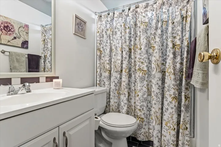 Full bath featuring vanity, a shower with glass sliding doors and tile patterned floors