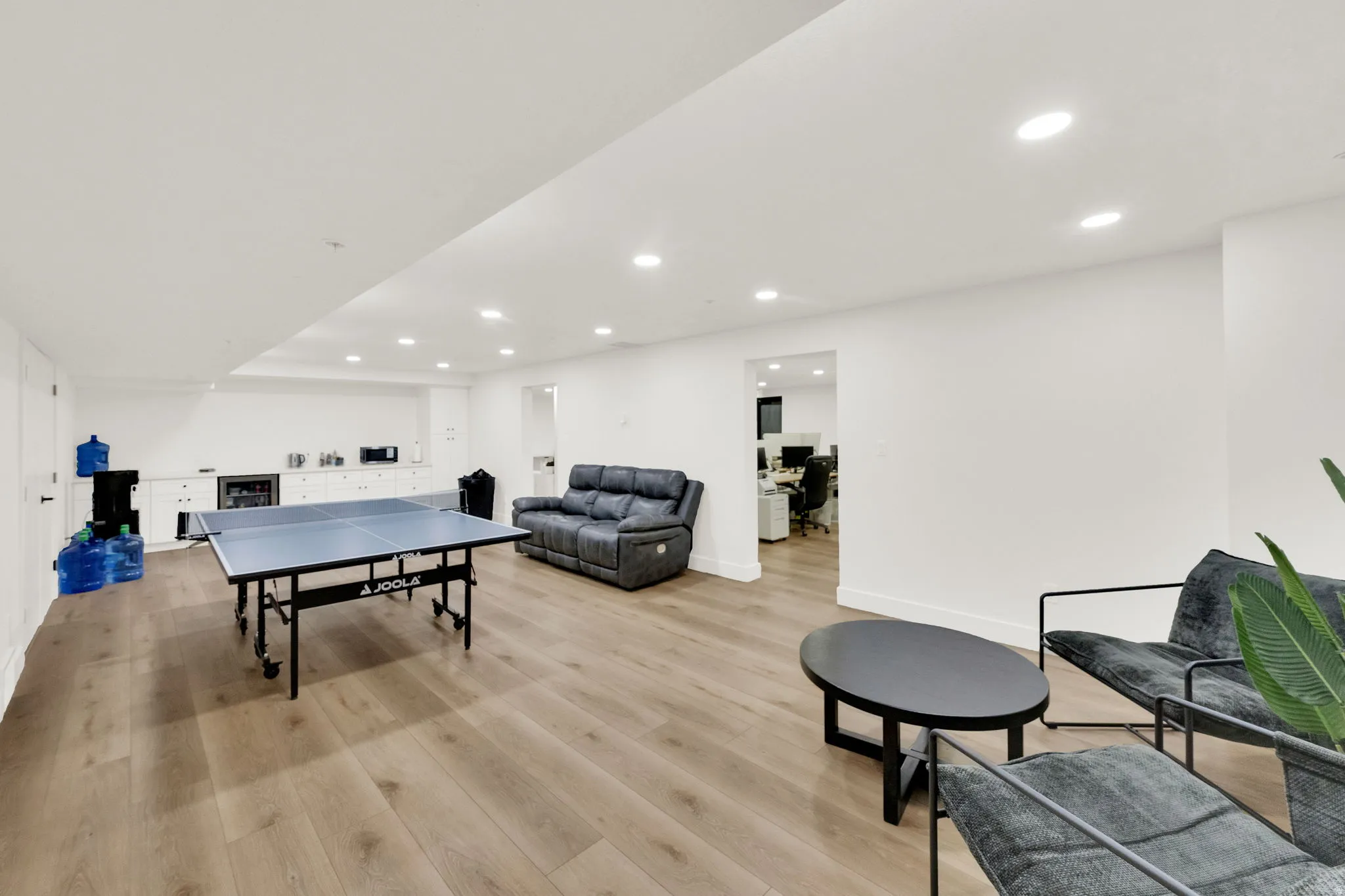 Game room featuring light wood-style floors, recessed lighting, and wine cooler