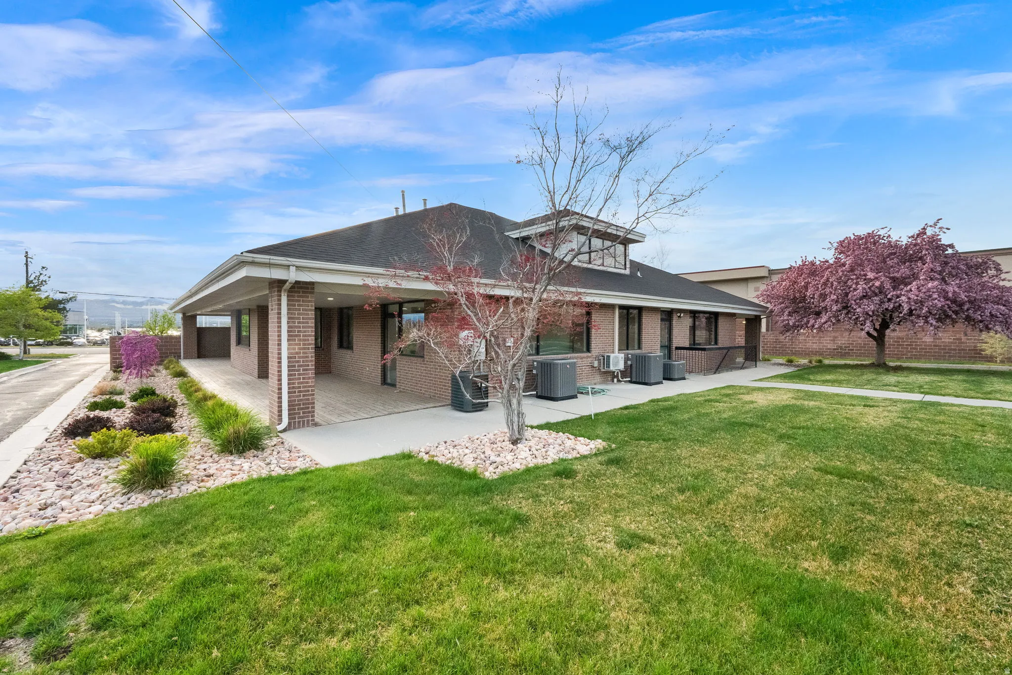 Rear view of property featuring brick siding, a yard, and a patio