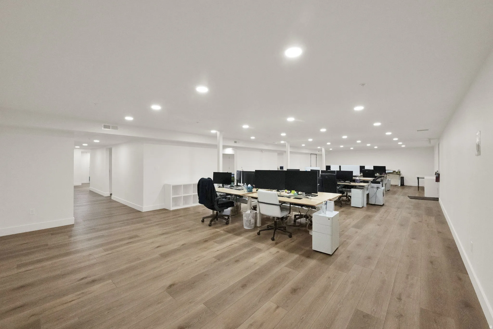 Home office with light wood-style floors and recessed lighting