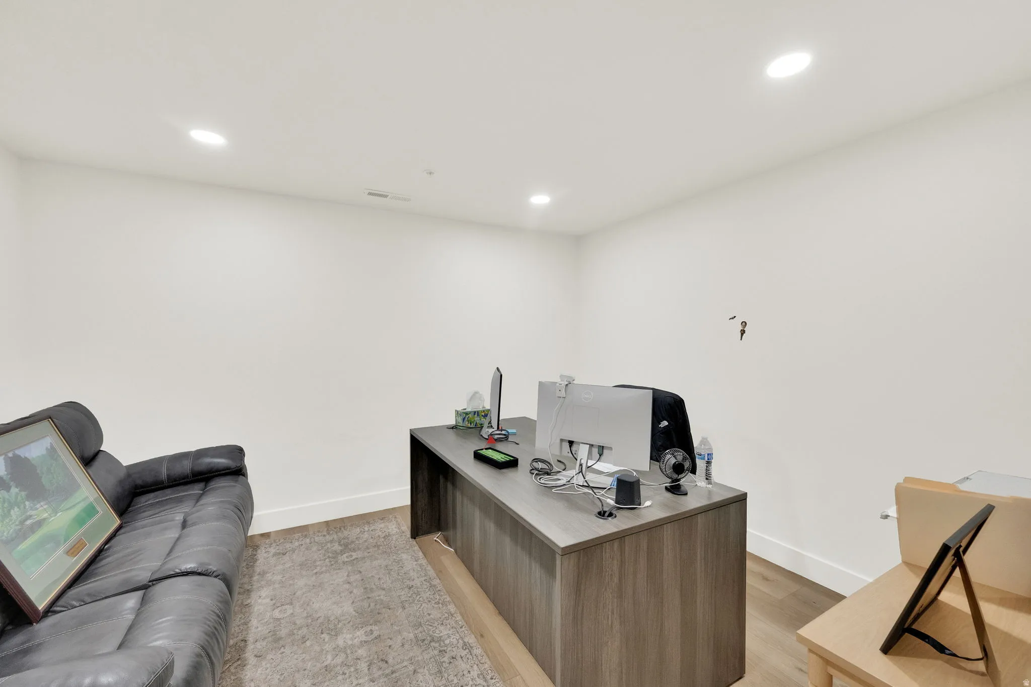 Office space with light wood finished floors and recessed lighting
