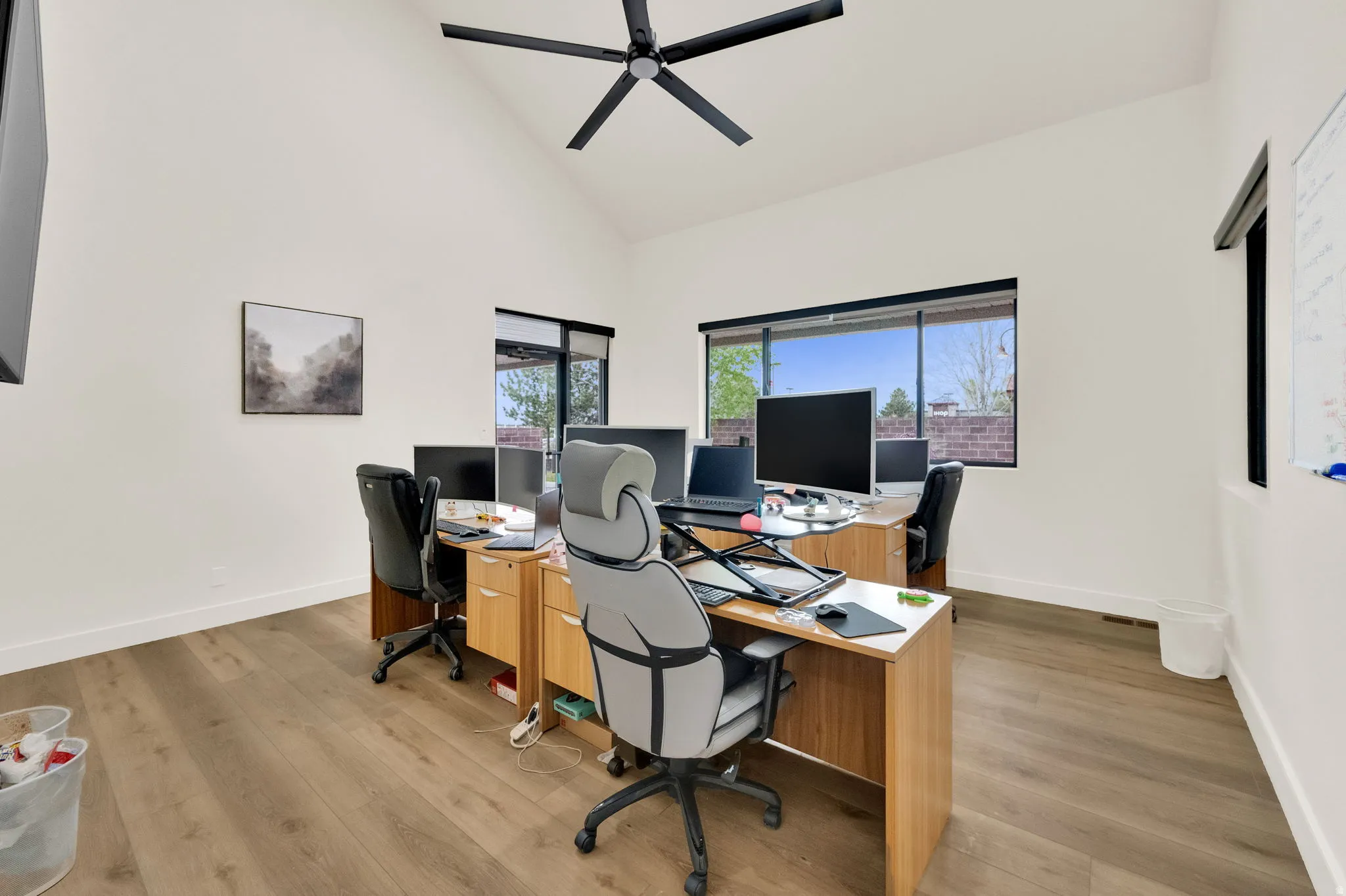 Office featuring lofted ceiling, light wood-type flooring, and a ceiling fan