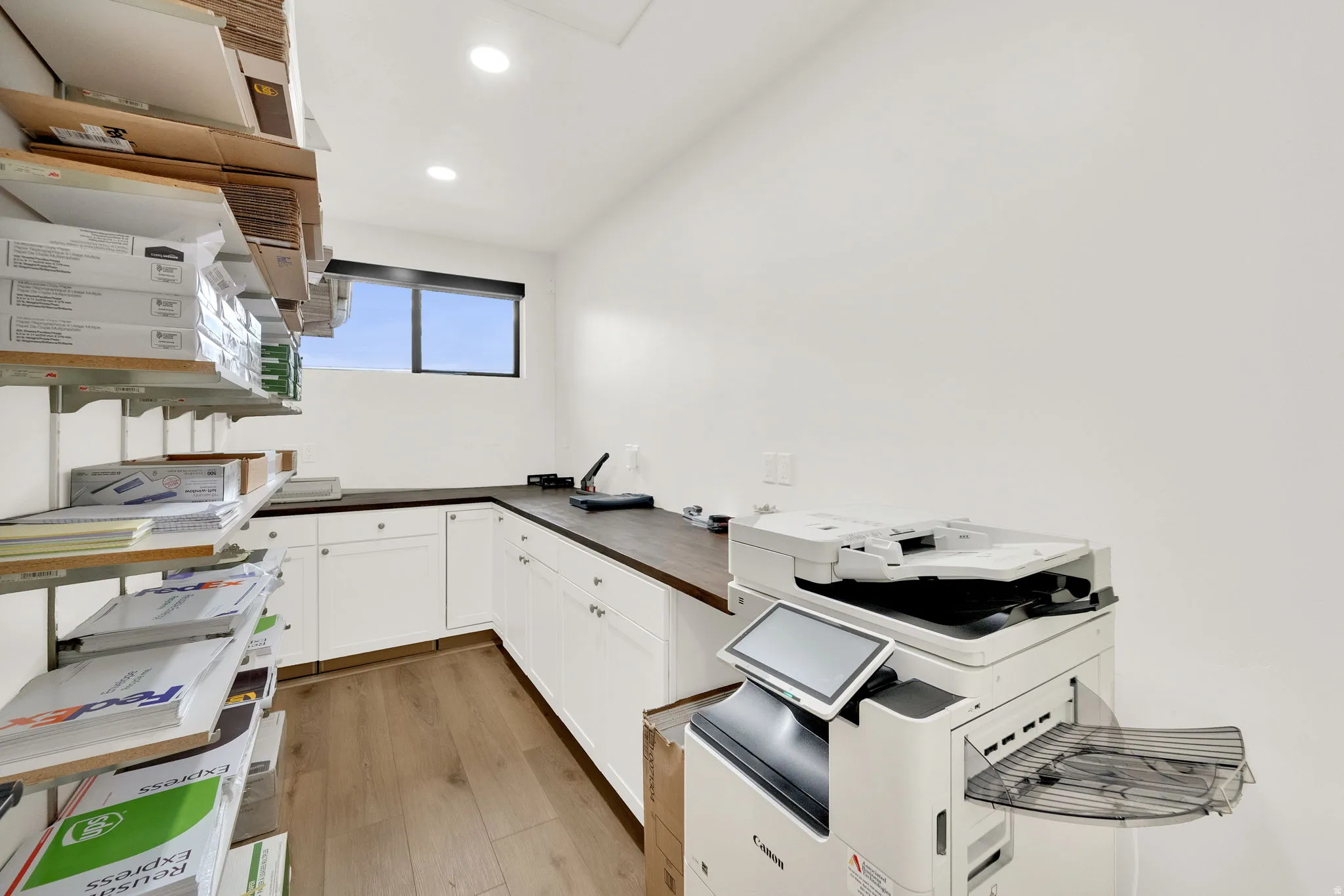 Kitchen with white cabinetry, light wood-style floors, recessed lighting, and wood counters