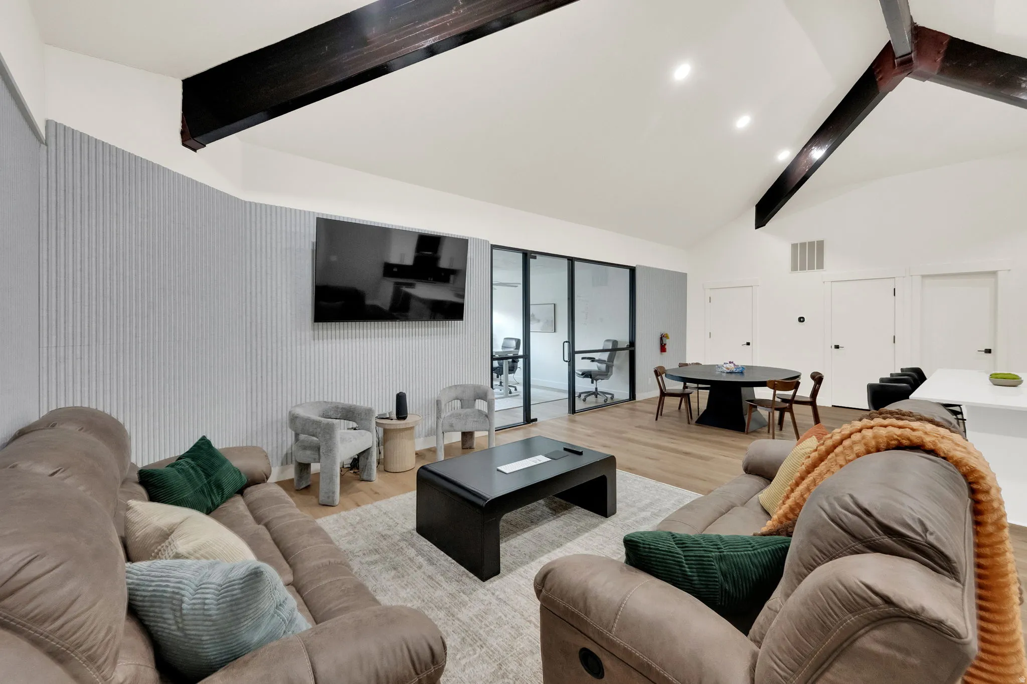 Living area with wood finished floors, lofted ceiling, and recessed lighting
