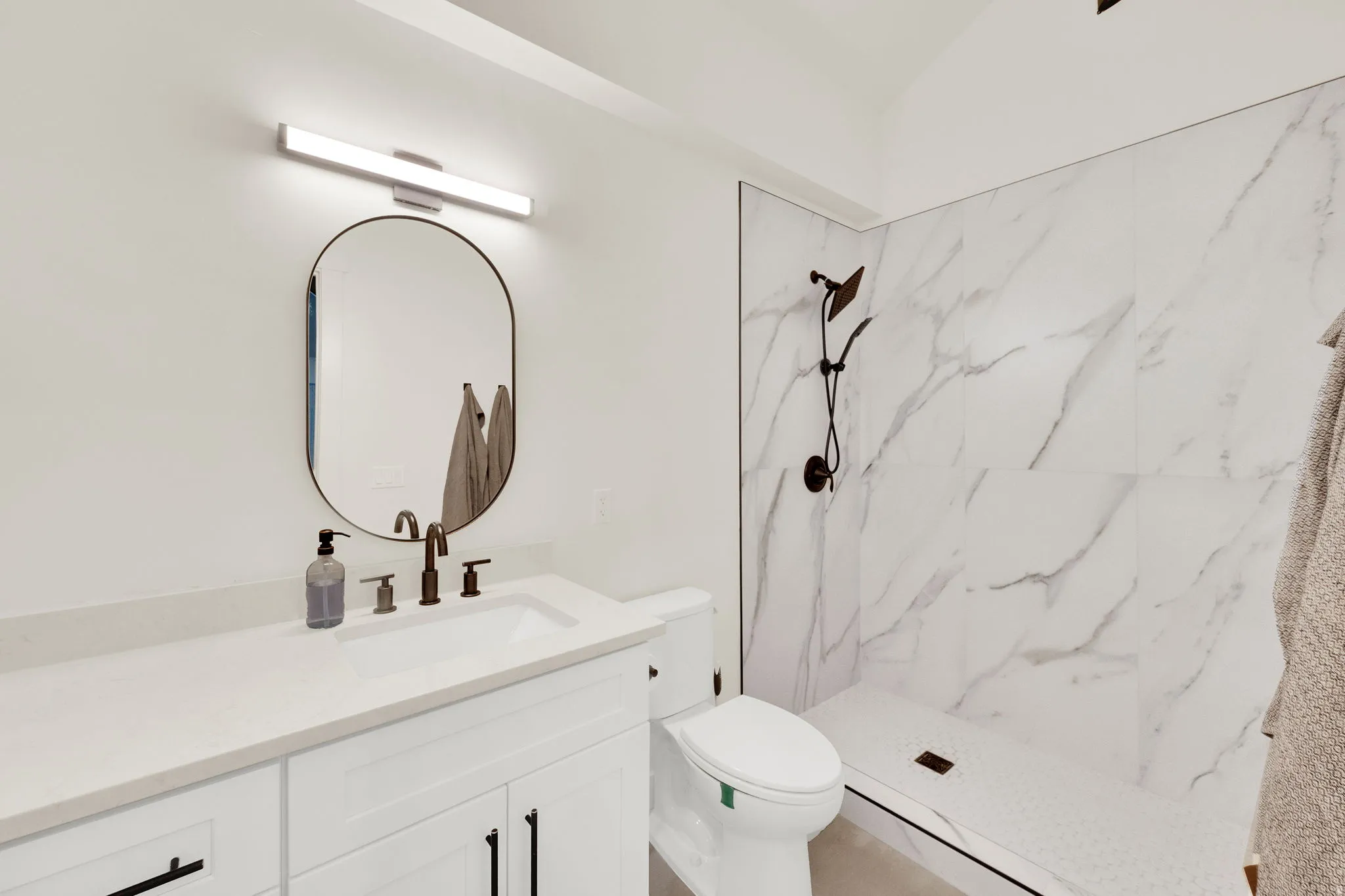 Full bath with vanity and a marble finish shower