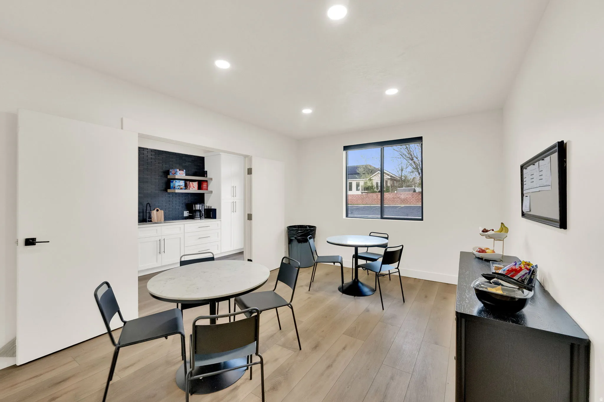 Dining room with light wood-style flooring and recessed lighting