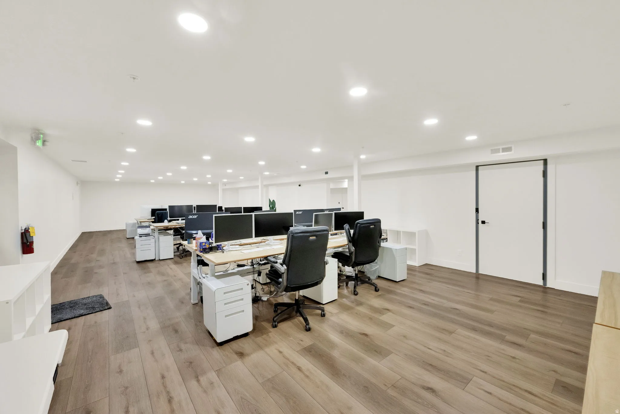 Office area featuring light wood finished floors and recessed lighting