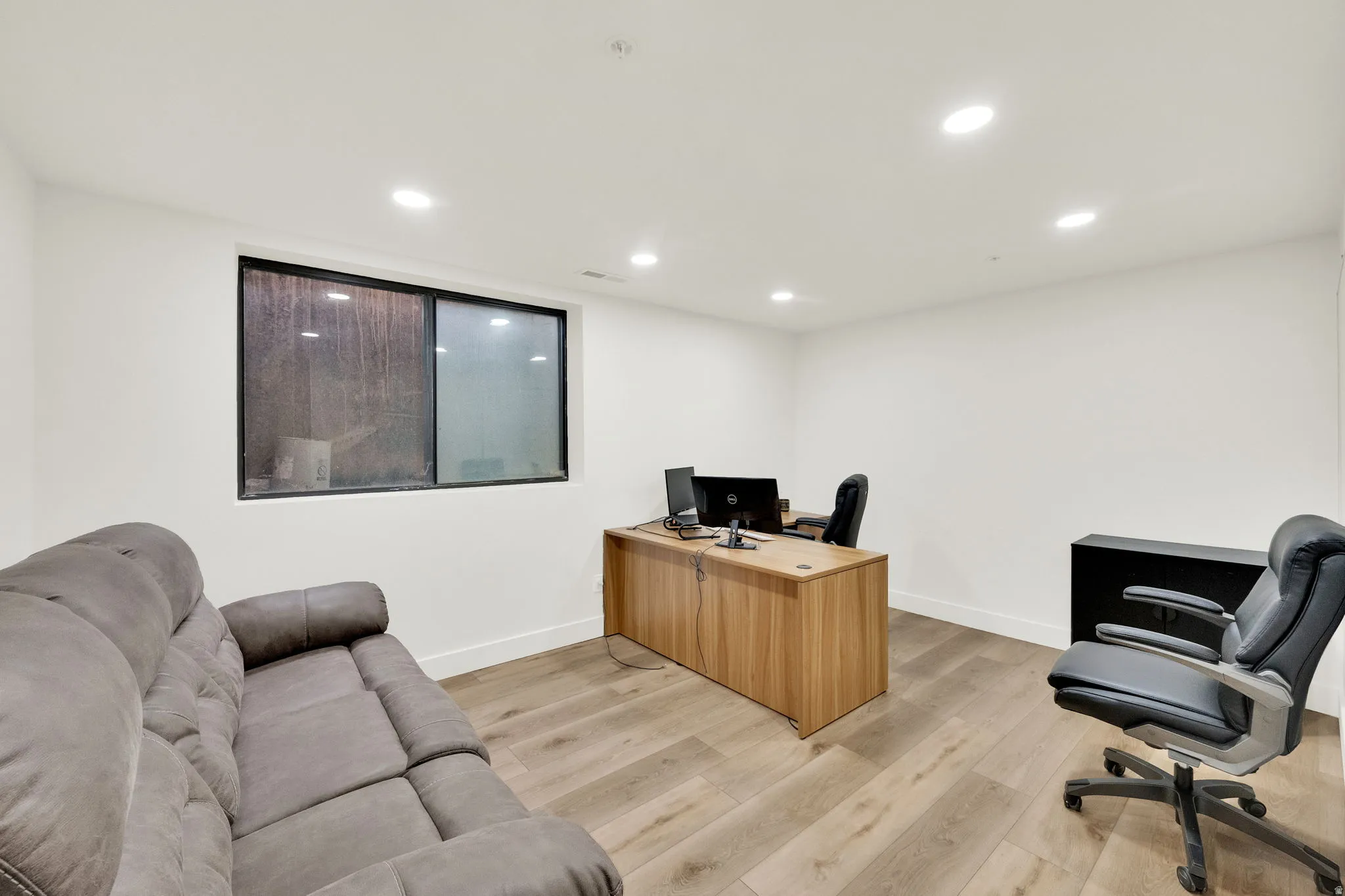 Office space with recessed lighting and light wood-style flooring