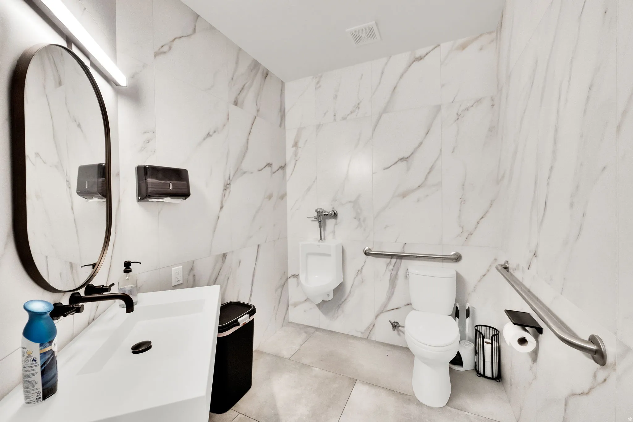 Bathroom with tile walls, vanity, and stone wall