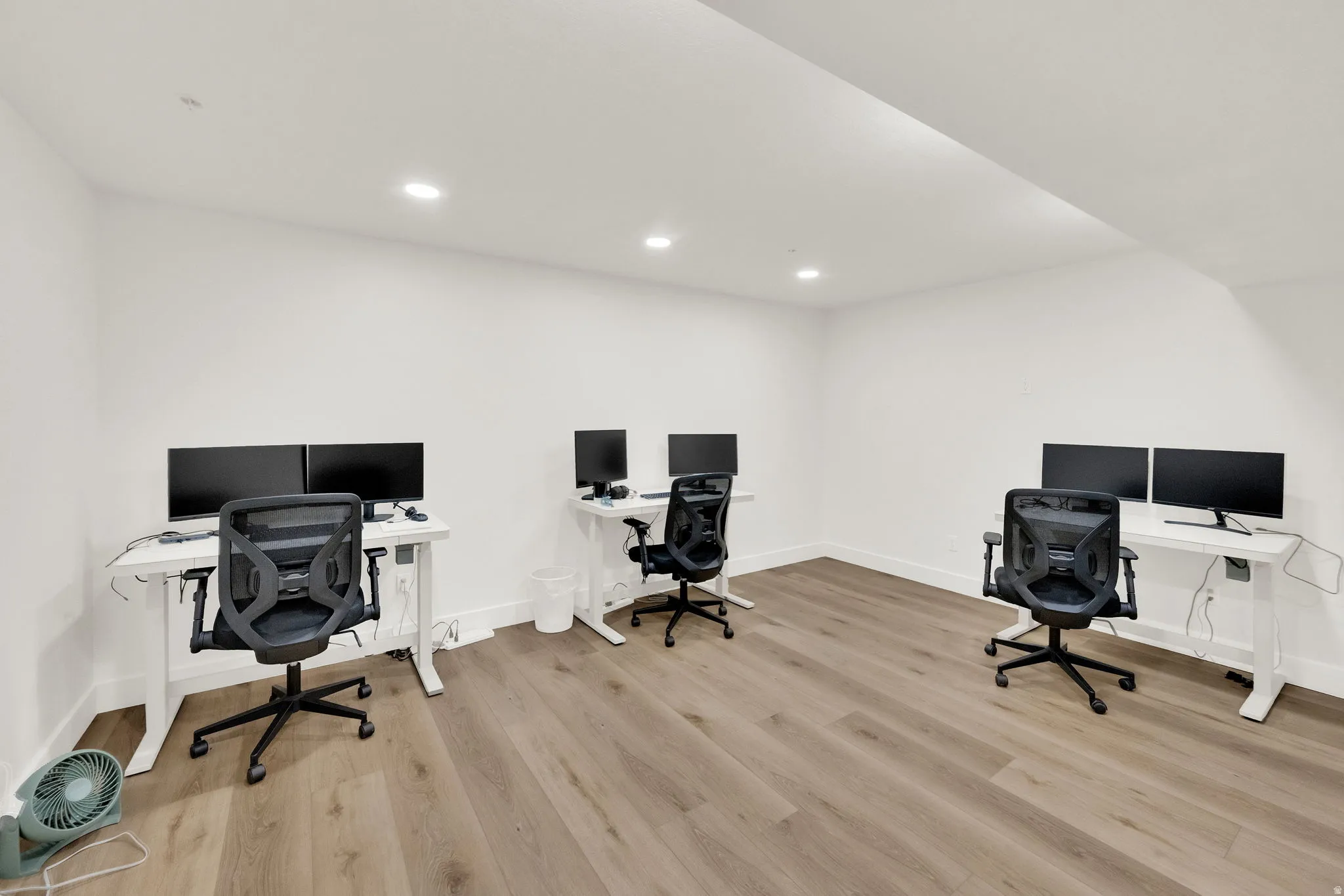 Office area with light wood-style flooring and recessed lighting