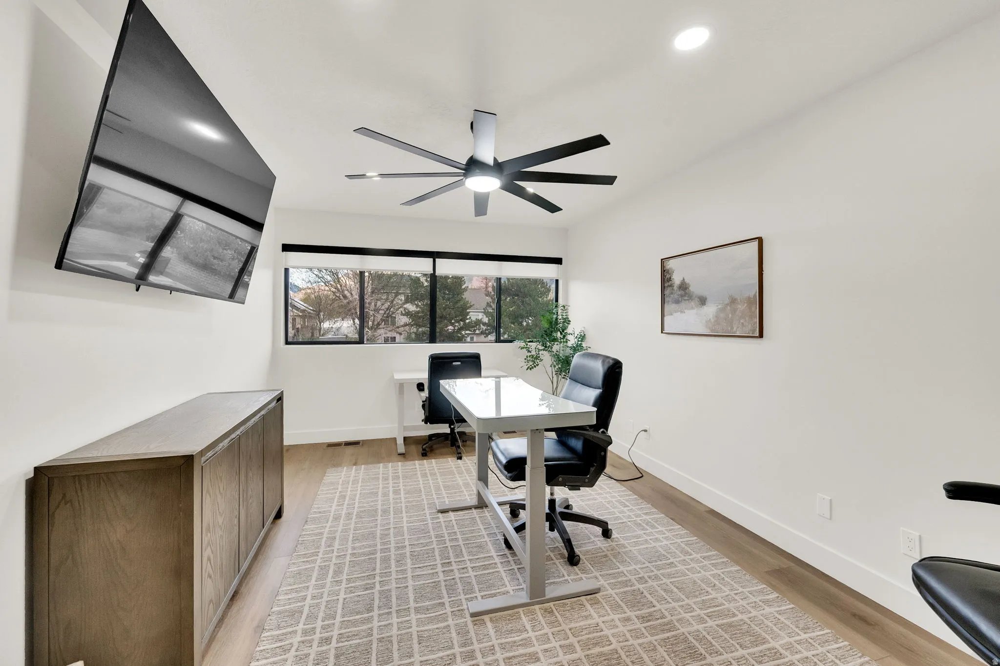 Office area featuring light wood-style floors, ceiling fan, and recessed lighting