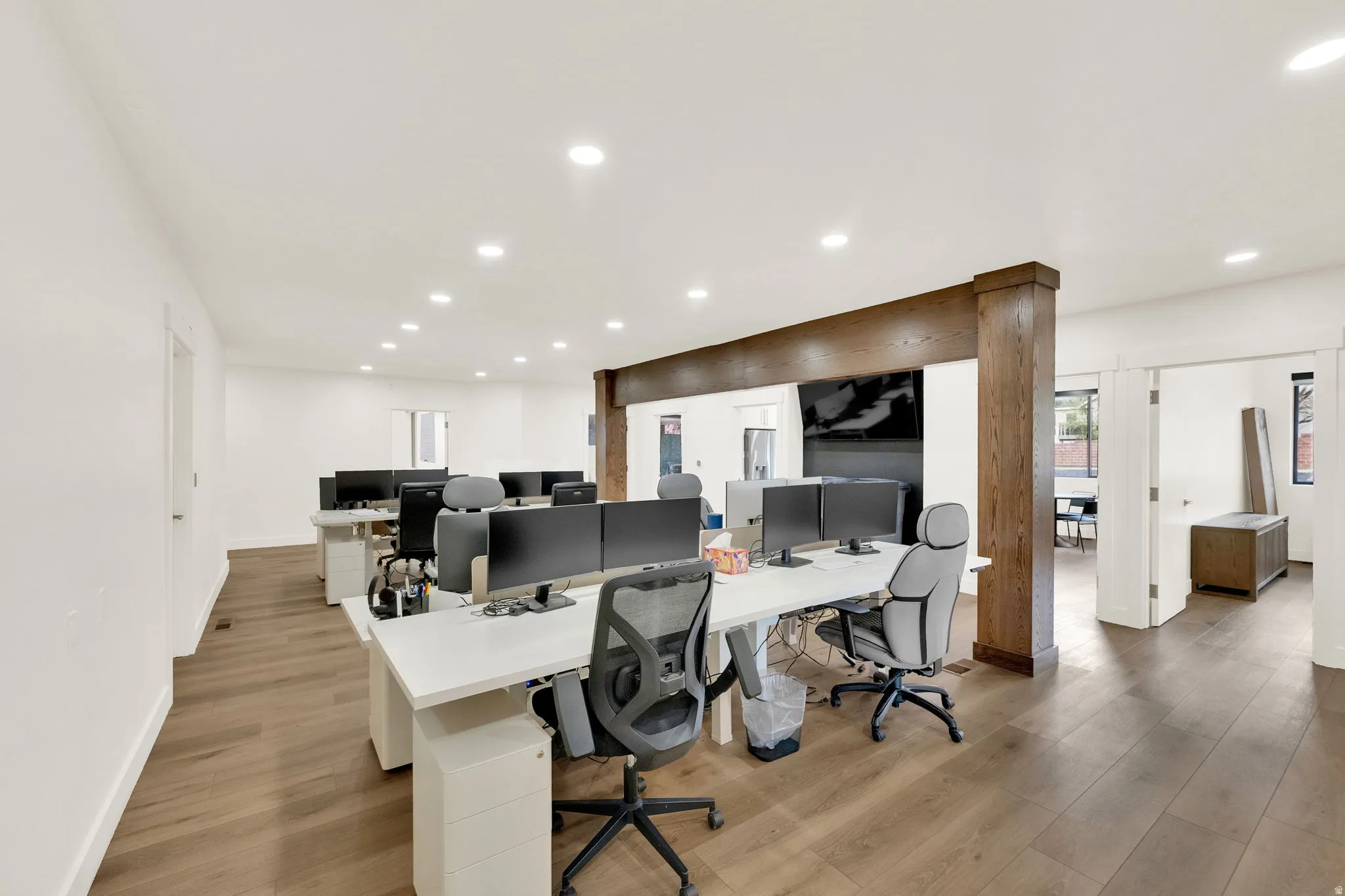 Office space with light wood-style floors and recessed lighting