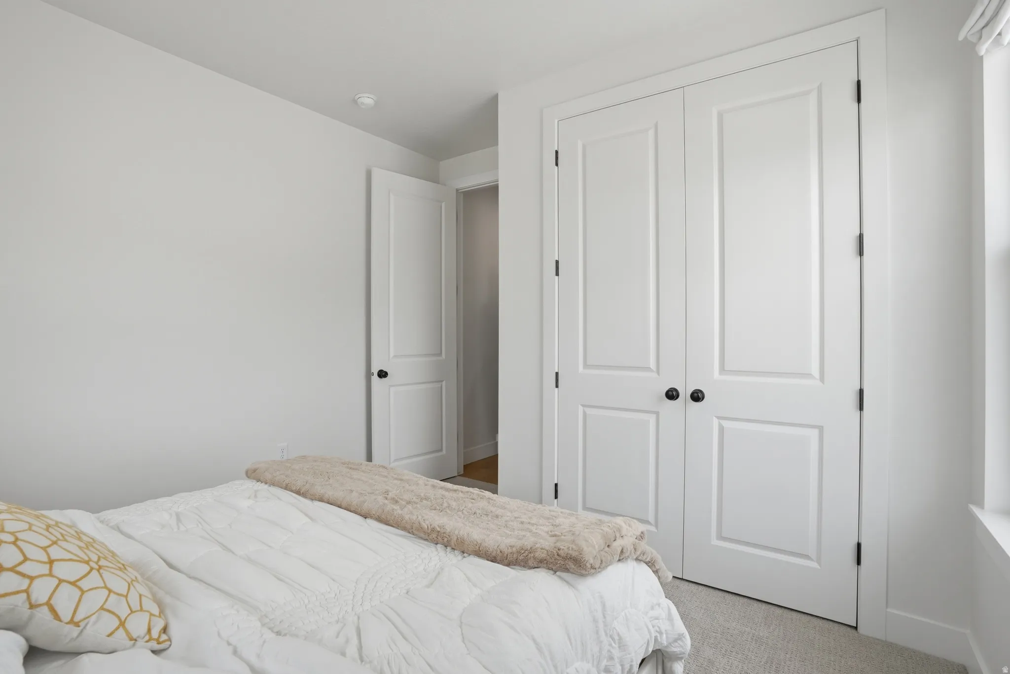 Bedroom with light colored carpet and a closet
