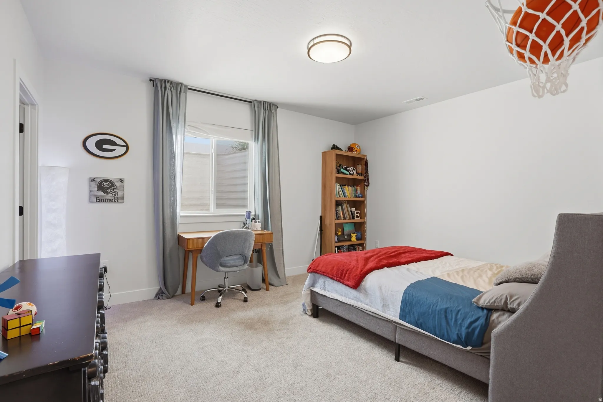 Bedroom featuring light carpet and an office area