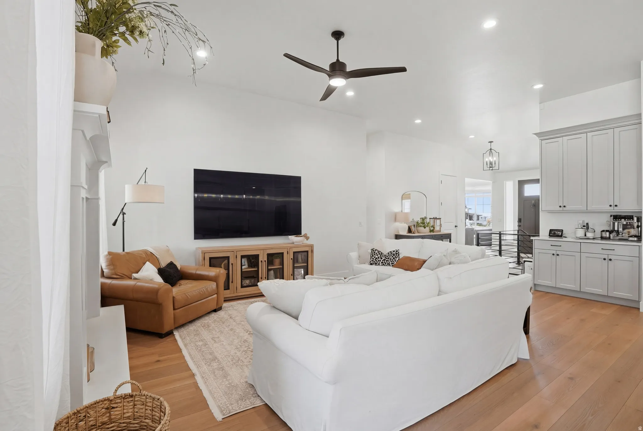 Living room with ceiling fan, light wood finished floors, and recessed lighting