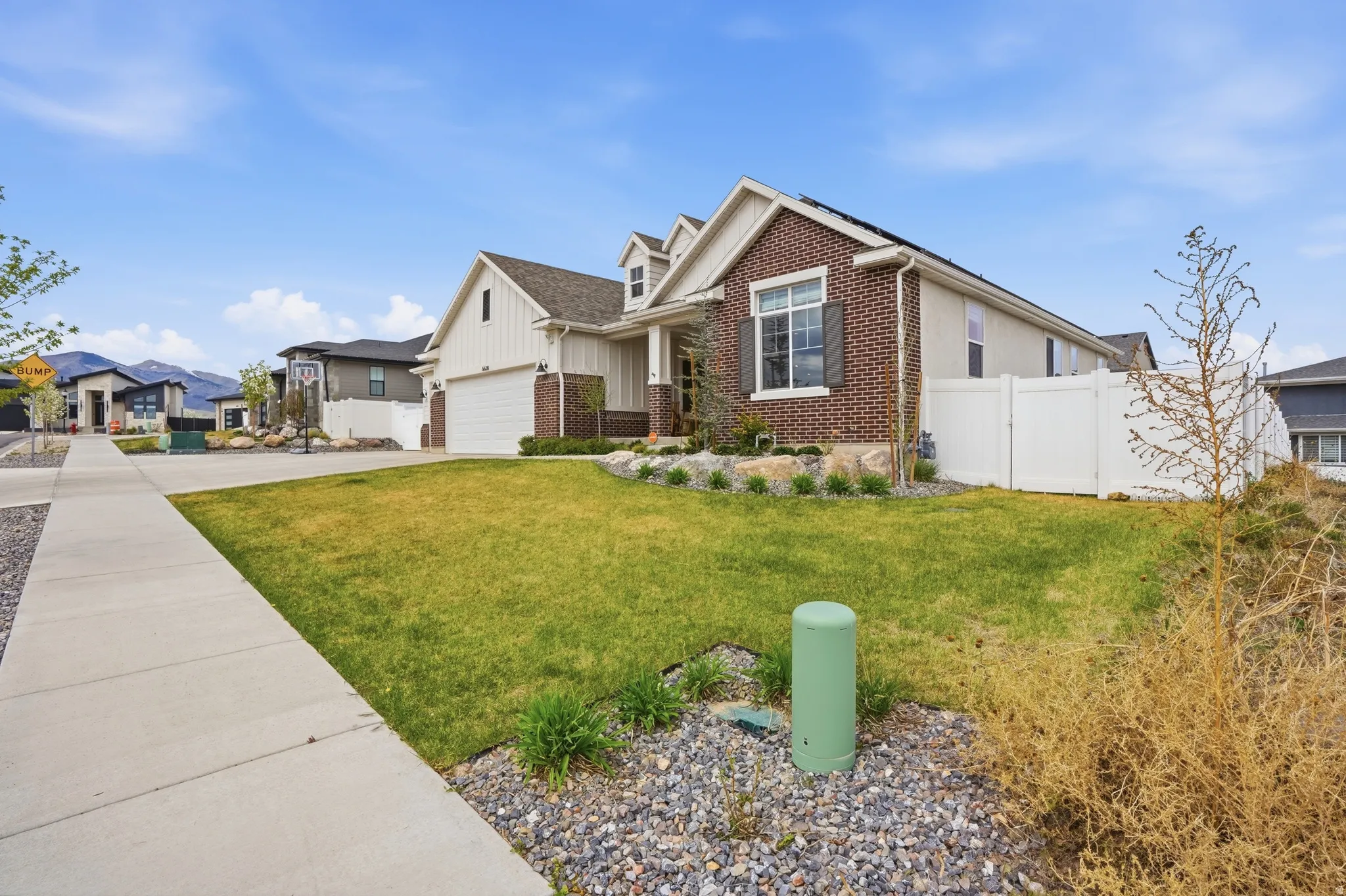 View of front facade featuring brick siding, concrete driveway, a residential view, and a garage