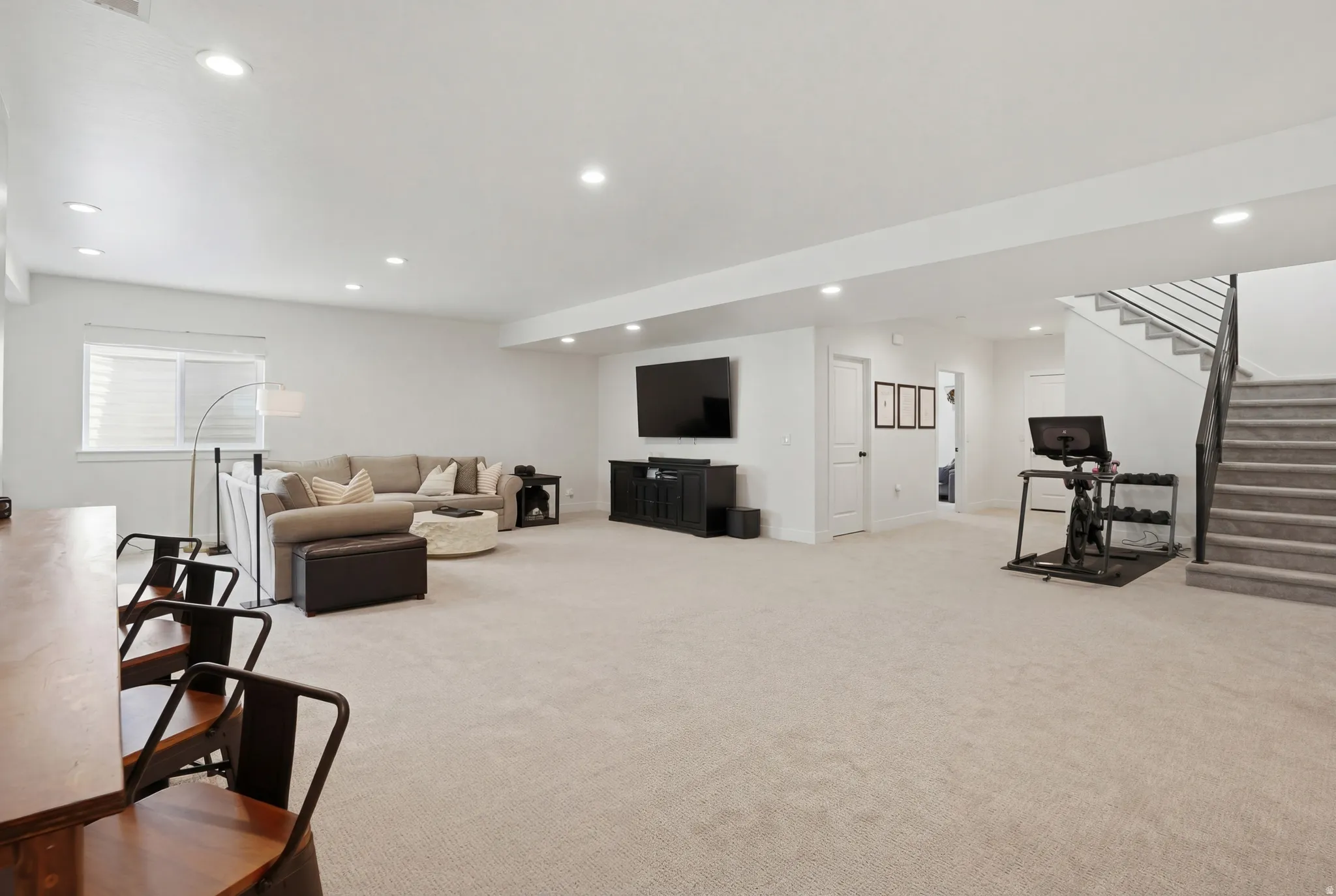 Living area with light colored carpet and recessed lighting