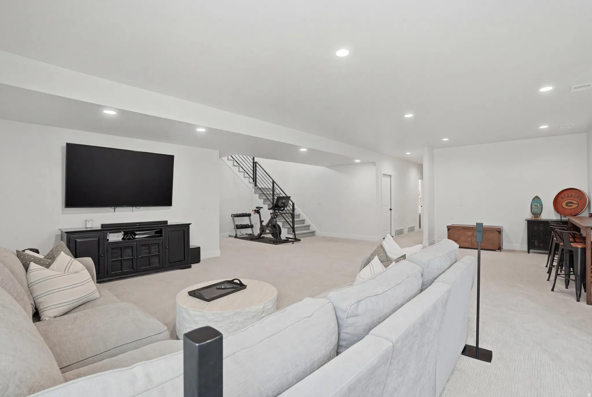 Living area with light colored carpet and recessed lighting