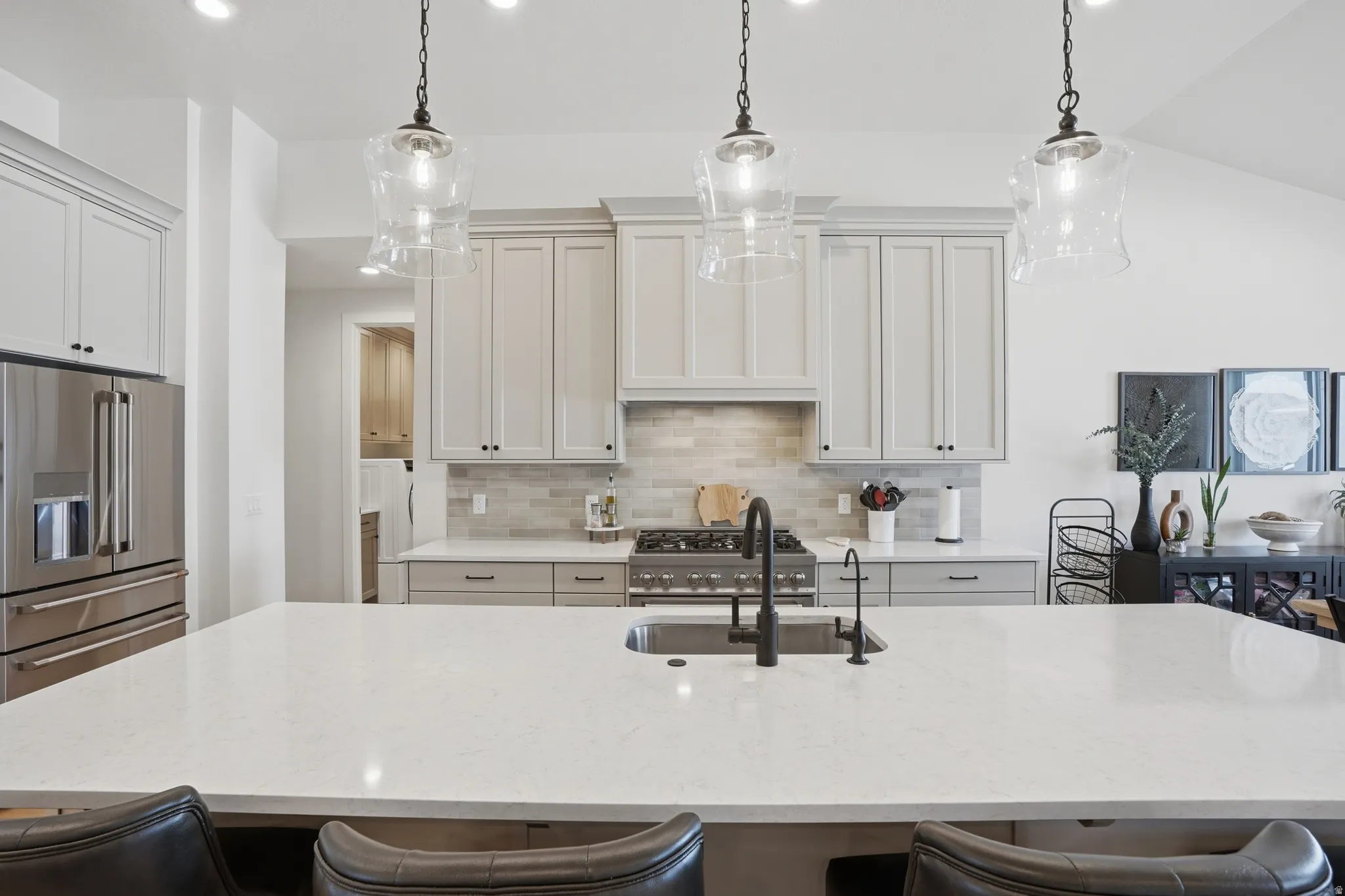 Kitchen featuring a breakfast bar, stainless steel appliances, decorative backsplash, and light stone countertops