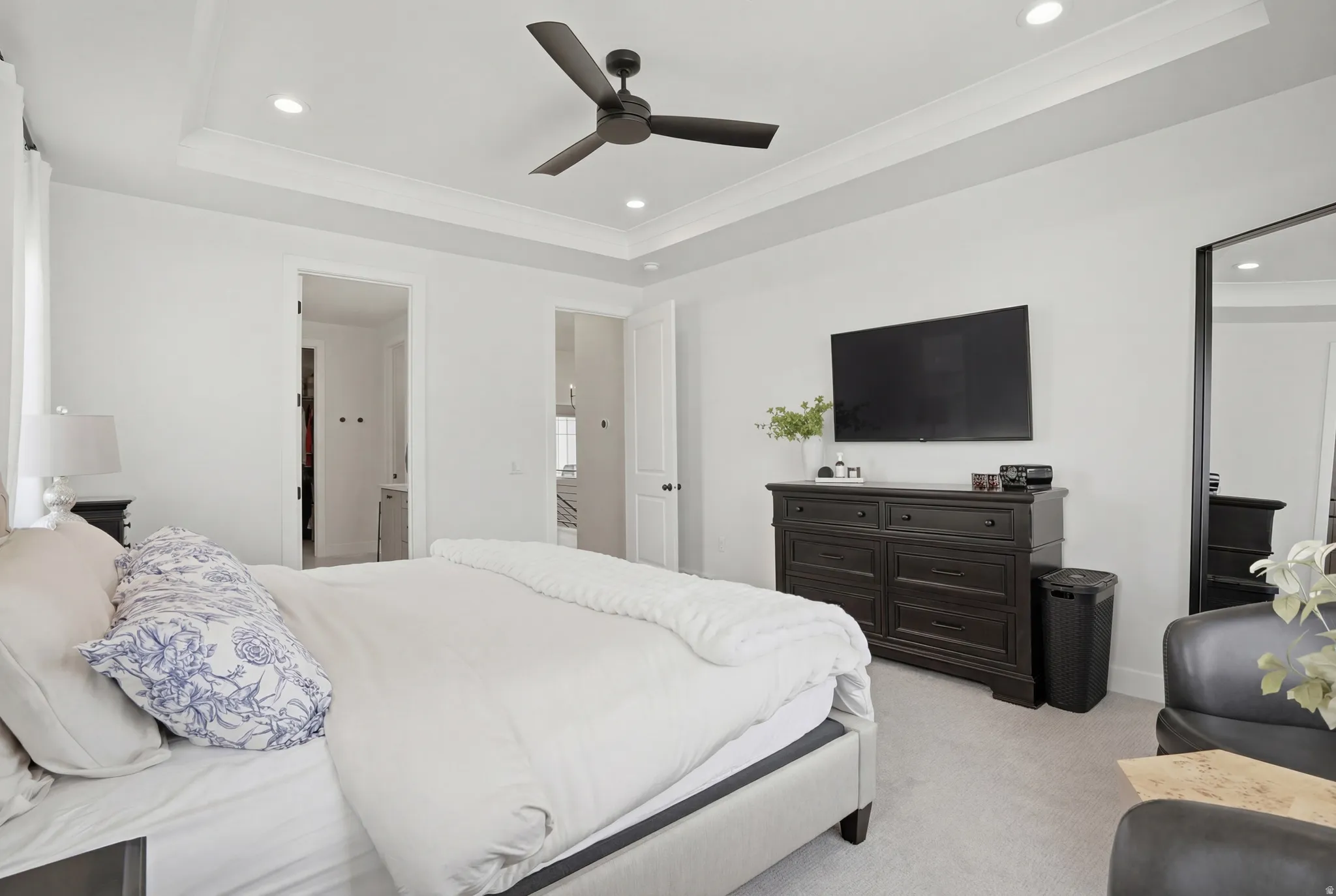 Bedroom featuring a raised ceiling, light colored carpet, recessed lighting, a ceiling fan, and ornamental molding