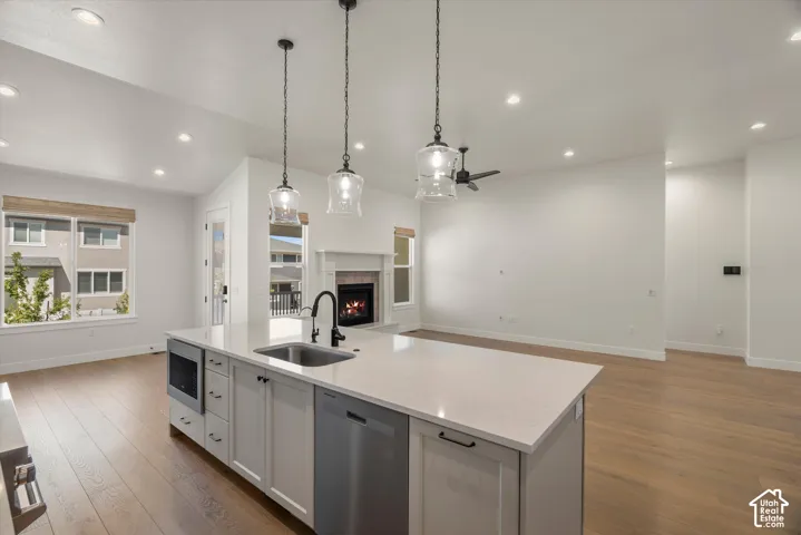 Kitchen island with integrated sink, stainless steel dishwasher, and built-in microwave