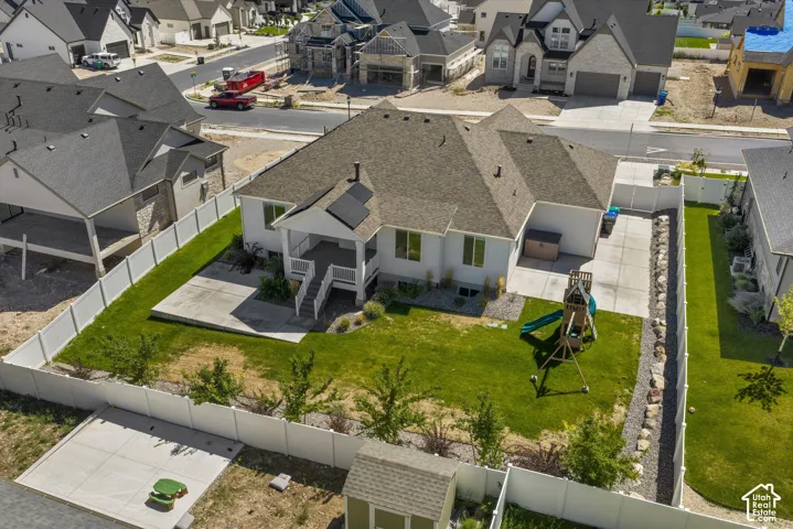 Expansive fenced yard featuring a manicured lawn, concrete patio, and mature landscaping