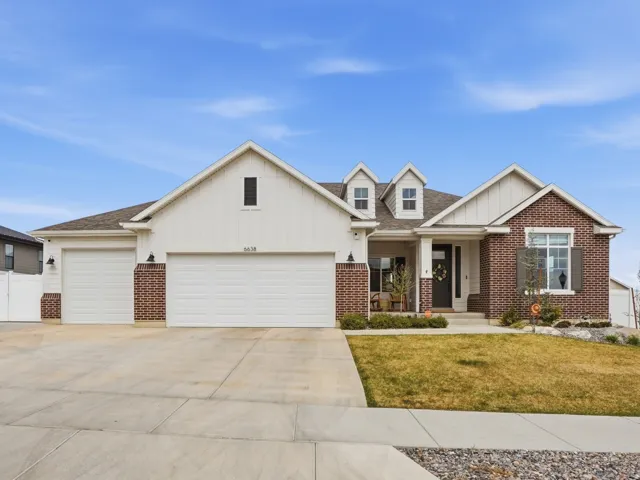 Craftsman inspired home with brick siding, board and batten siding, and an attached garage