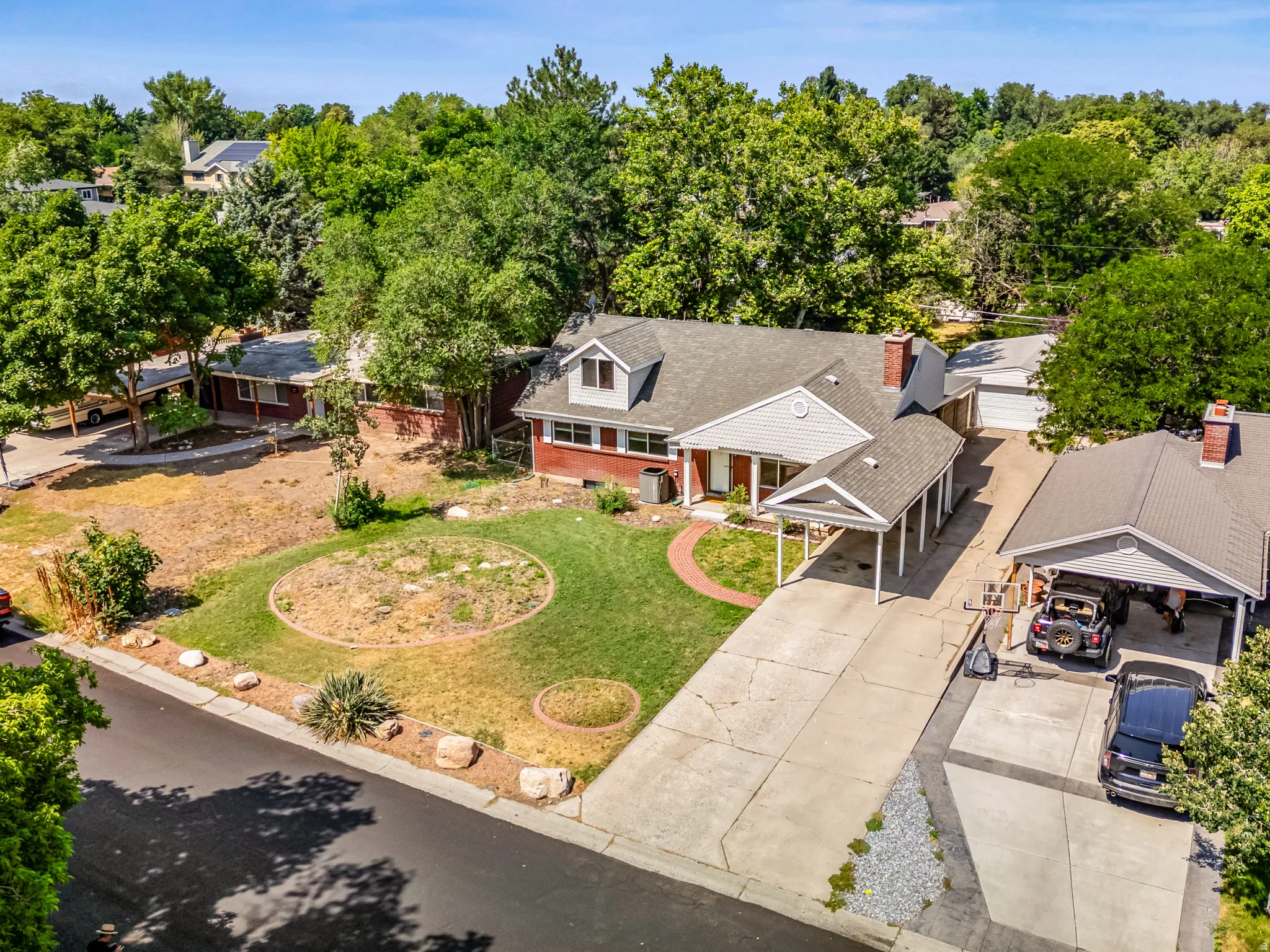 Aerial view of property and surrounding area with a tree filled landscape